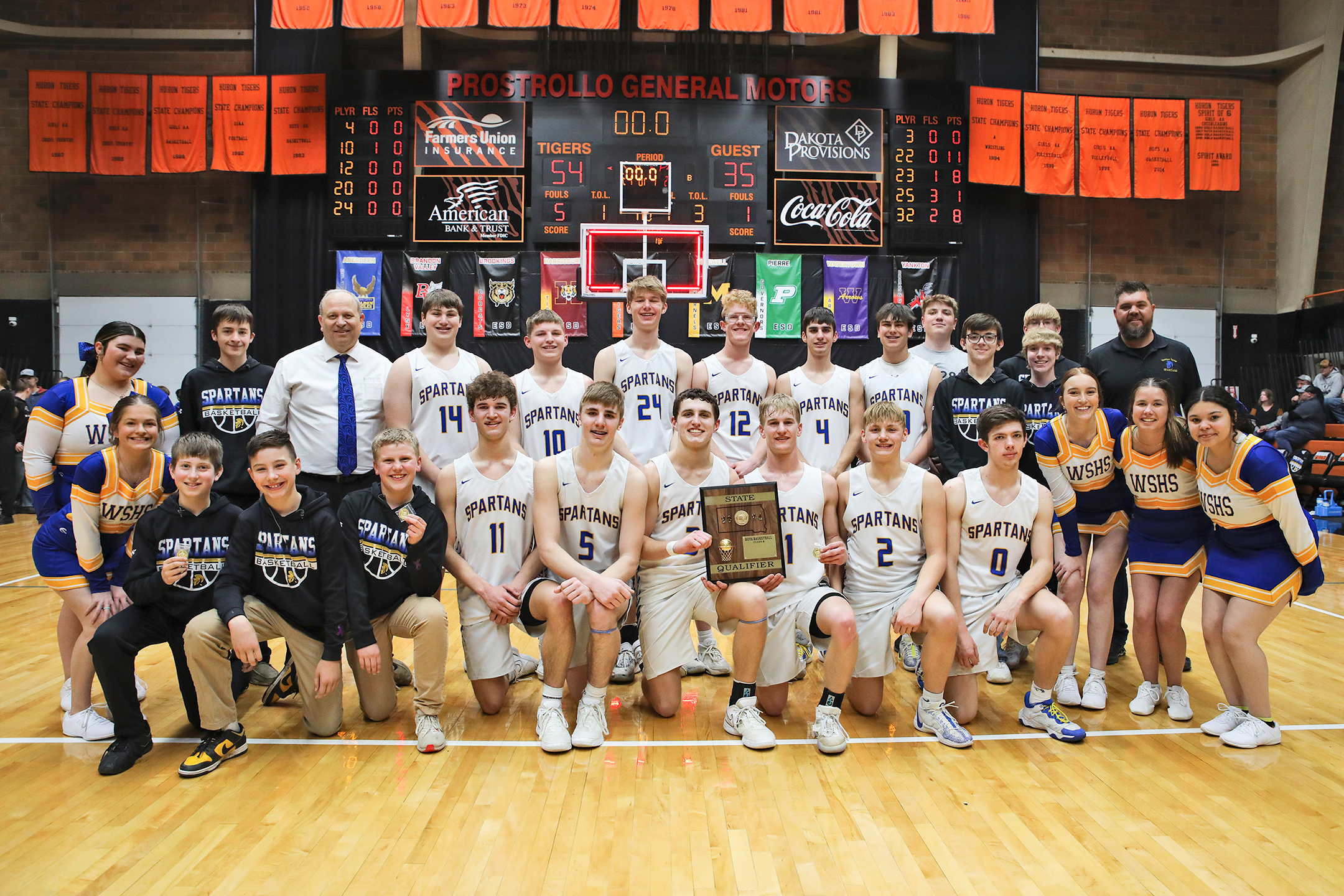 Shown immediately following a 54-35 win over Waverly-South Shore in the SoDak 16 at the Huron Arena, the Spartans Boys Basketball team proudly displays the state qualifier plaque. 
