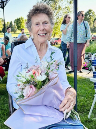 Kathy Dean holds flowers presented in recognition of her 37 years of dedication to the Shakespeare Garden Society. (PHOTO COURTESY GWYNETH FASTNACHT)