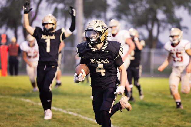 Cayson Walters crosses the goal line for a Wolsey-Wessington touchdown as teammate Cooper Timm raises both arms to signal the score during the Warbirds’ 56-6 homecoming victory over Sunshine Bible Academy. 