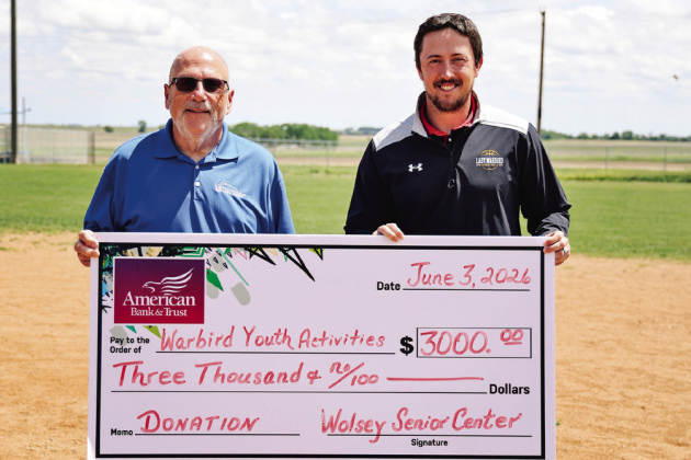 Wolsey Senior Center board member Dave Burnison, left, presents a $3,000 donation to Riley Donovan to support the Wolsey Summer Recreation baseball program. The contribution helped expand the program to include both tee ball for ages 4-5 and coach-pitch baseball for ages 6-7. Nearly 40 youth are participating this summer, with games scheduled Mondays and Wednesdays throughout June. (KRISTI HINE / TRUE DAKOTAN)