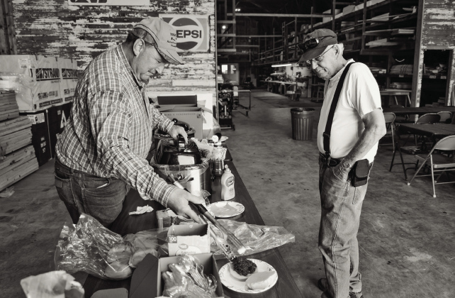 Farmland Building Supply Board Member Dean Duxbury serves a burger to Mike Hazzard during the company’s annual Customer Appreciation Day on June 3 in Wessington. The event featured burgers, beans, chips, cookies and refreshments as a thank-you to customers for their continued support. (KRISTI HINE / TRUE DAKOTAN)