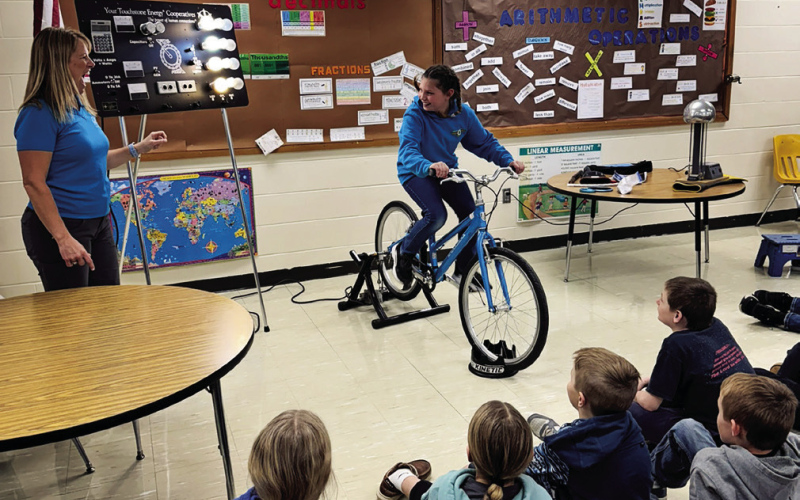 Students demonstrated how electricity is made with a pedal bike generator that powers light bulbs.