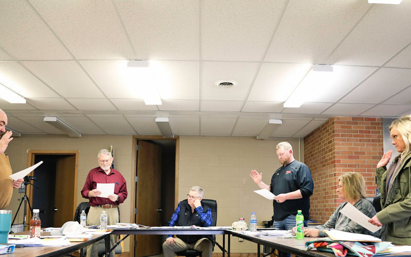 Blue swears in (clockwise from left, standing with right hand raised) Ward 1 incumbent Ryan Knipfer and Ward 2 incumbent Layton Schimke, whose terms were vacant and ran unopposed. Natasha Waters, elected to represent Ward 3 on April 12, 2022, also took her oath of office.