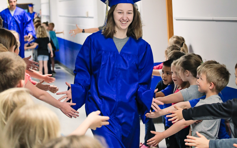 Seniors and preschool - sixth graders alike enjoyed the beloved tradition of the elementary school hallway walk through last Friday. Kali Roduner high fives elementary kids eager to interact with the graduates.