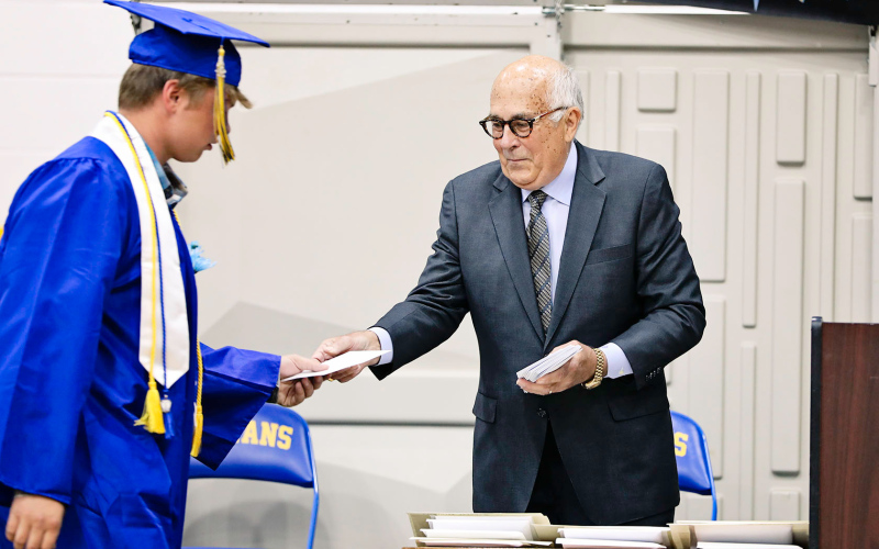 Commencement speaker Steve Grove handed each graduate an envelope, filled with a surprising assignment due July 1.