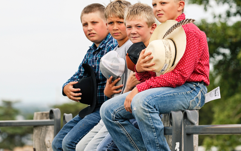 Local youth JR Hine, Jace Kolousek, Casen Waters and Mauer Jones remove their hats for the National Anthem.