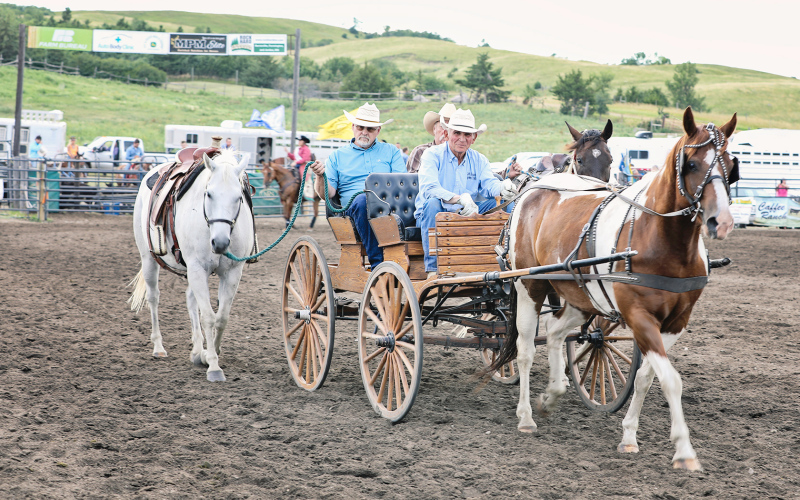 Elton Kaus, Phil Wipf and Darrell Deneke, members of the Kyle Evans Memorial Wagon Train and Foothills Rodeo Committees pay a moving tribute to the late Steve Deneke and Lynn Ogren.