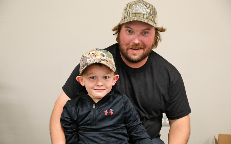 Ducks Unlimited member Bailey Willman and helper Kash Woodin take a quick break from selling raffle tickets to pose for a photo.