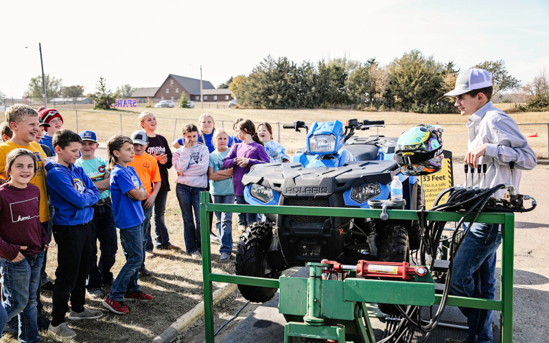 Third and fourth grade students listen to Schimke as he discusses ATV safety and instructions for interacting with the simulator.