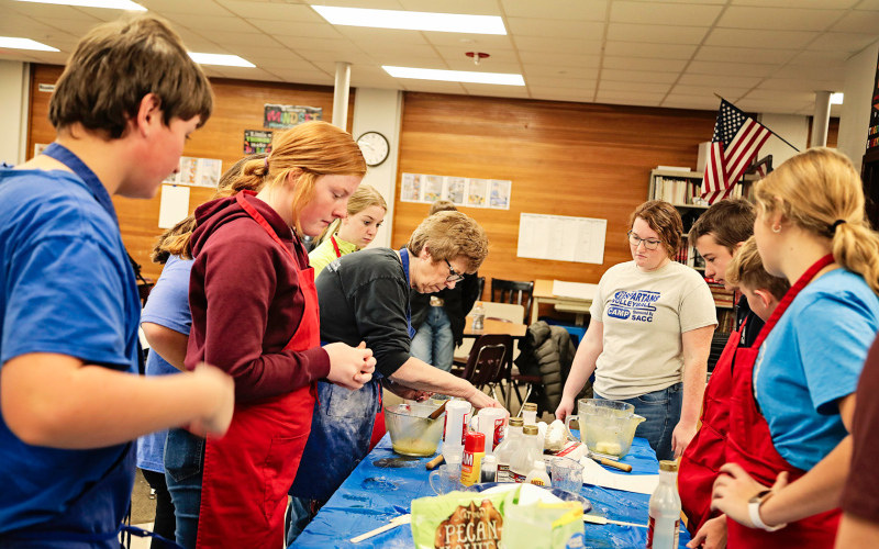 WSHS Family and Consumer Sciences/Technology Skills teacher Charlotte Mohling teaches eighth graders the basics of pie making with help from senior Riley Roduner.