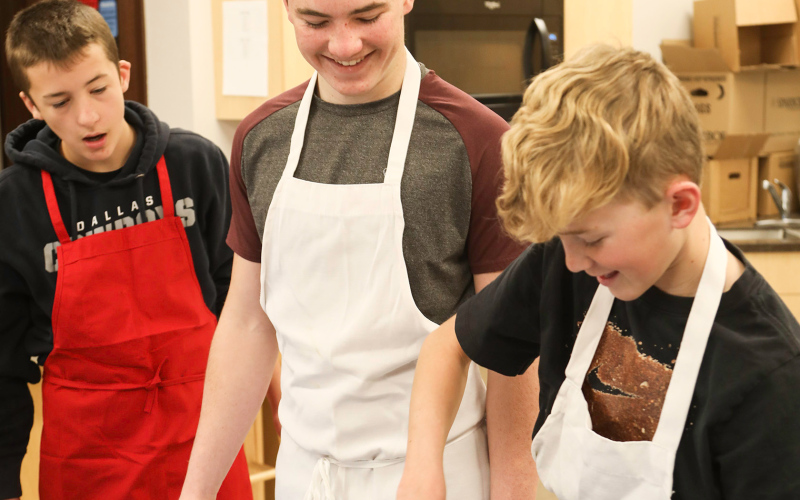 Shown left to right, Teagan Scheel and Nathan Gaikowski look on as Tucker Thompson shows them the ins and outs of egg whisking.