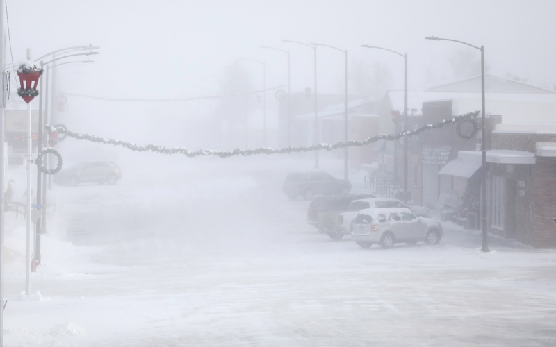 At 16 degrees below zero, Thursday’s temperatures forced many to rethink their Christmas plans. Several vehicles can be seen through the blowing snow parked at Springs Food Market to stock up on groceries.