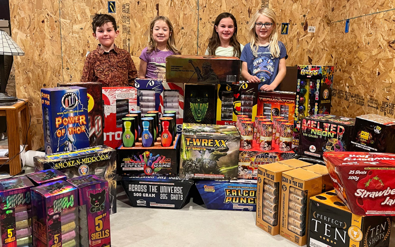 Finley Weber, Austen Bultsma, Hadley Weber and Hayden Bultsma are almost as excited as their parents for the New Year’s Eve community fireworks show planned in the South Gulch. They are shown with part of their parents’ fireworks inventory. PHOTO COURTESY CRISTIN WEBER