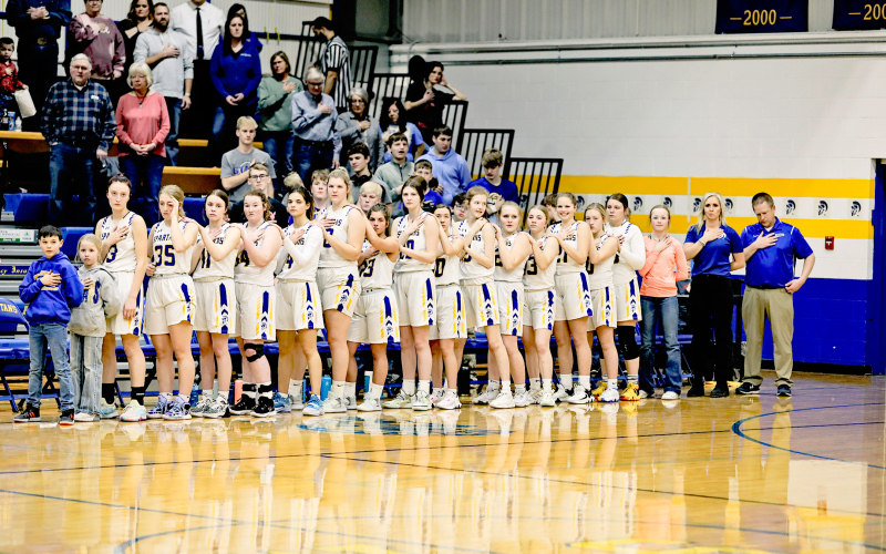 The Girls Spartans Basketball Team stands at attention during the National Anthem before the final regular season game of the year won at home against James Valley Christian by a score of 54-43.