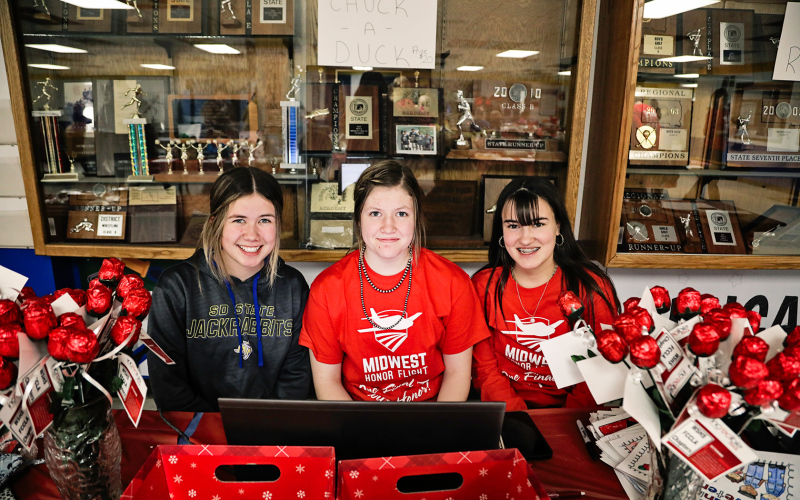 Jada Kolousek, Mercedes Jones and Remie Roduner helped distribute red candy roses to area veterans.