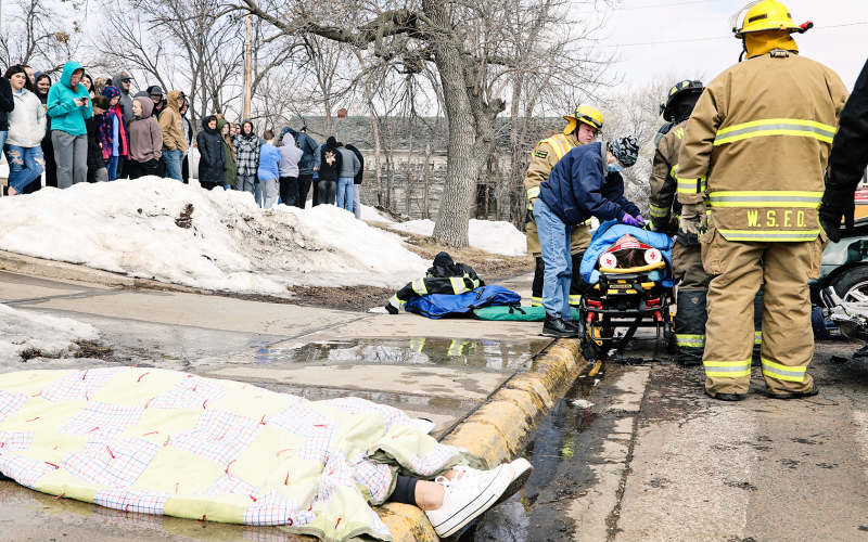 The outcome was very different for a student actor who was not wearing a seatbelt in the mock crash, shown covered from head to toe with a blanket on the perimeter of the scene.