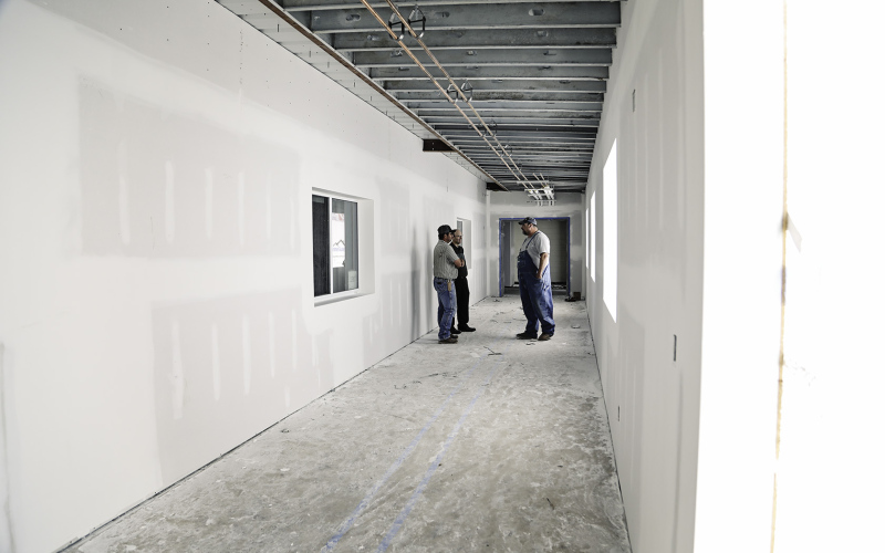 Members of the building committee are shown in one of the connecting corridors between the elementary school building and new facility. 