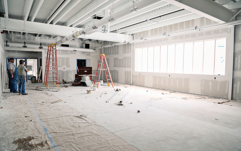 Wessington Springs School District Board Chair Todd Grohs, Board Member Darrick Van Dyke and School Superintendent Dr. Michael Ormsmith discuss progress on the rec center/auxiliary gymnasium project at a construction committee meeting last Thursday. They are pictured in the fitness center area of the project.