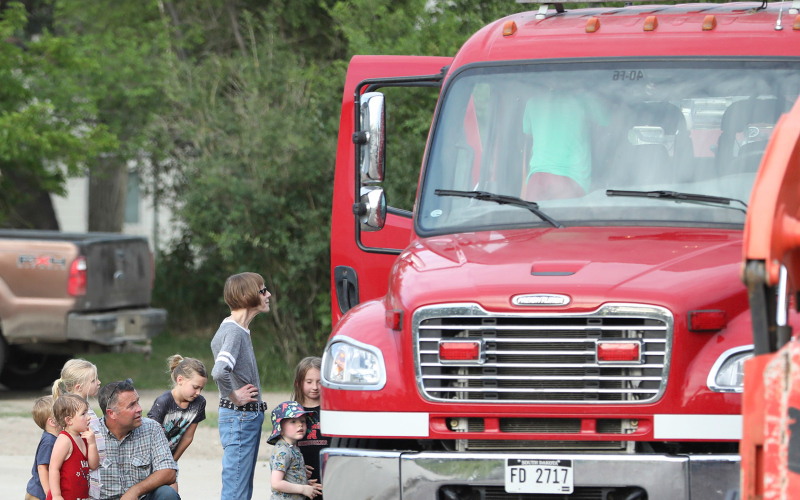 Kids and adults alike patiently await their turn for a ride in a fire truck.