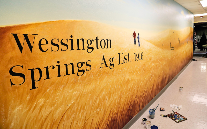 The once-drab hallway leading into the Vo-Ag shop at Wessington Springs High School (WSHS) has been transformed through the work of local artist and WSHS alumna Kenzee Schafer, funded through a grant to help promote the local FFA chapter. KRISTI HINE / TRUE DAKOTAN