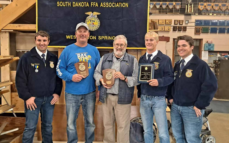Representing the champion 2022 and 1961 WS FFA Chapter Meats teams are shown with their plaques. Left to right: Ridge Roduner - 2022 team, Scott Kolousek - 1961 team (representing his father Dick), Dr. Tom Dean - 1961 team, Blake Larson - 2022 team, Carter Gaikowski - 2022 team.