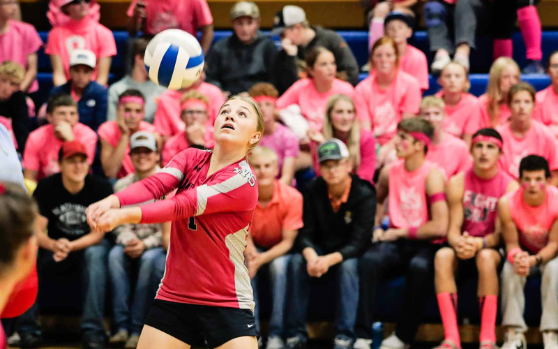 A lively student section decked out in pink can be seen behind Raylee Fagerhaug as she gets under the ball during Volley for a Cure last Thursday.