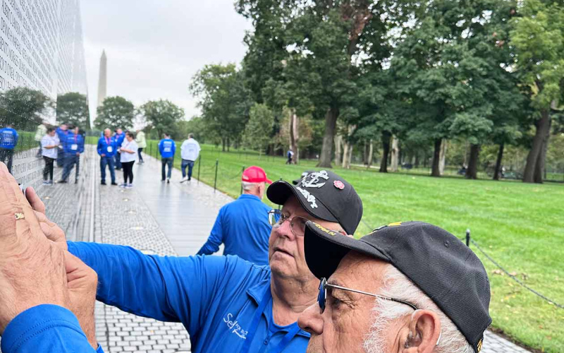 Bernie Maxwell and Herman Eilers sketch names of former classmates at the Vietnam Memorial.