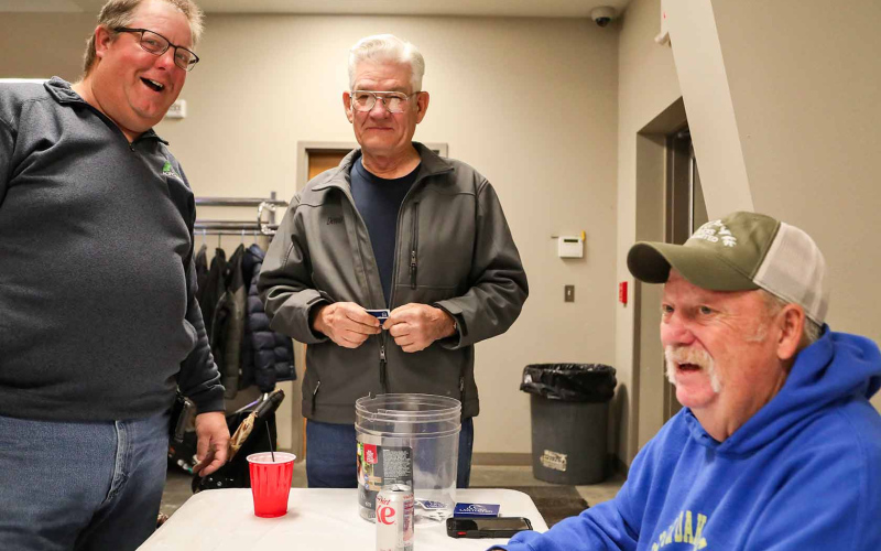 Scott Vaske, Dennis Scheel and Darrell Deneke have fun while trying their luck at one of the many games in play during the banquet.