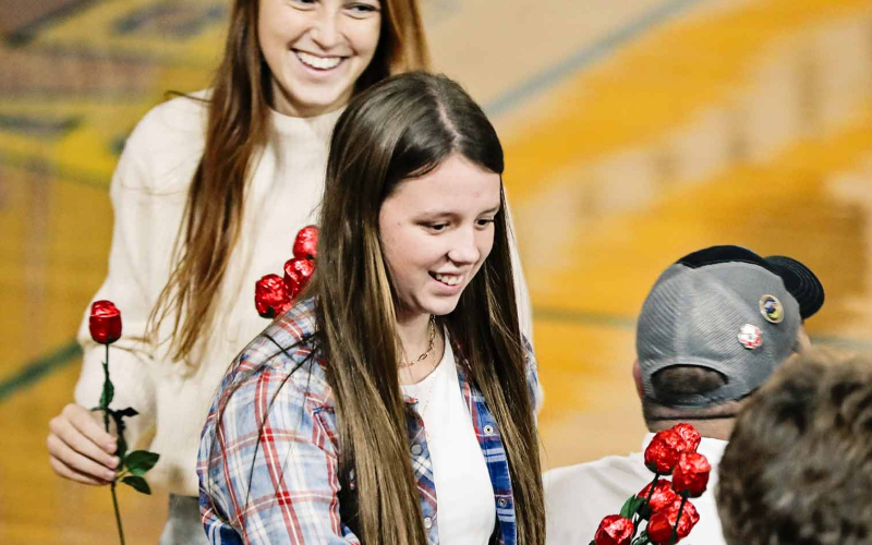 Veterans were asked to stand and given roses by high school students including Caroline Witte and Hannah Heezen