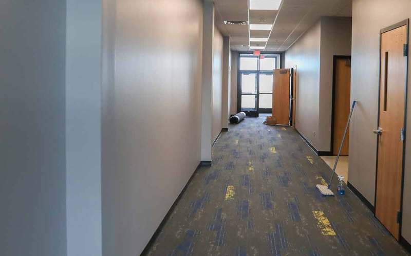A Spartan blue and gold pattern adorns the carpet in the entryway, hallway and foyer.