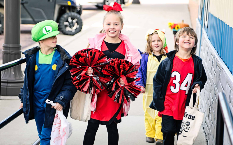 Carson, Dally Jo, Harper and McCrae Nickels run up the ramp of the True Dakotan looking for candy during Tuesday's Annual Halloween Walk.