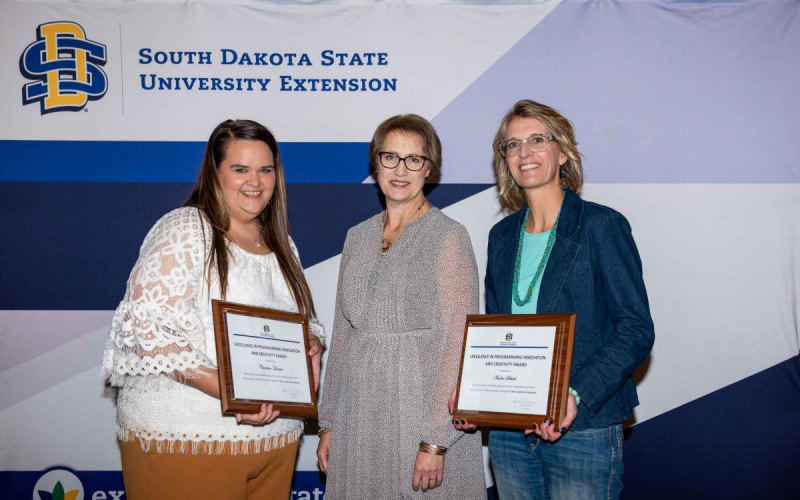From left, Caroline Hansen, SDSU Extension Director Karla Trautman, and Audra Scheel, 4-H Youth Program Advisor – Sanborn and Jerauld/Buffalo counties. Hansen and Scheel received the Excellence in Programming Innovation and Creativity Award. Scheel also received a Multi-Disciplinary Program Seed Grant for the Beef 2 School project from SDSU Extension Director Karla Trautman. PHOTO COURTESY SDSU EXTENSION