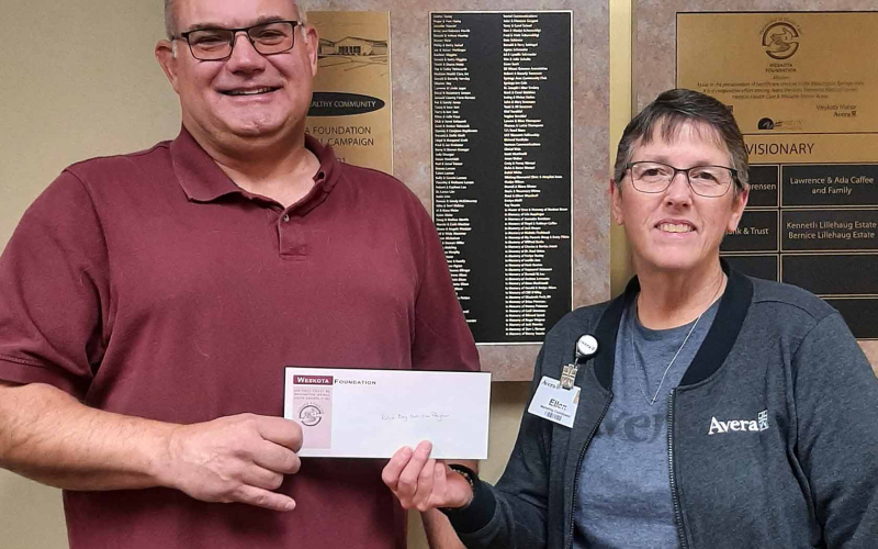 Ellen Powell (right), Marketing &amp; Foundation/Wellness Assistant at Avera Weskota Memorial Hospital, presents a $5,000 donation to Rod Housman representing the Blue Bag Nutrition Program.