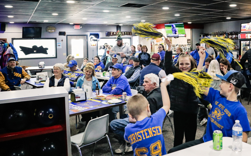 In the foreground, Cecil Fagerhaug, Carlayna Waters and Casen Waters celebrate and get the crowd revved up at Sunday’s watch party at Pin Twisters.
