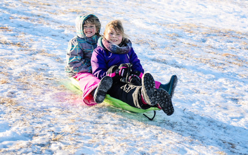 Sabrina Schaller and Memphis Hanson zip down the sledding hill Sunday. T