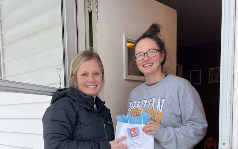 Dacia Mitchell (above left) delivers a gift bag of books to new mom Shelby Schooler.
