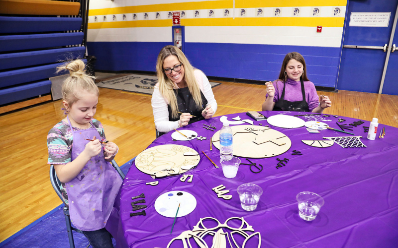 Hilary Grohs (center) and two of her daughters, Amelia and Gianna participate in a hands-on craft activity at the Crazy 8’s Creations booths.