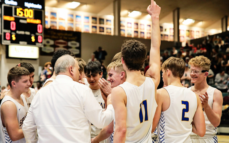Coach Kenny Huether celebrates with the Spartans after the win at the Corn Palace.
