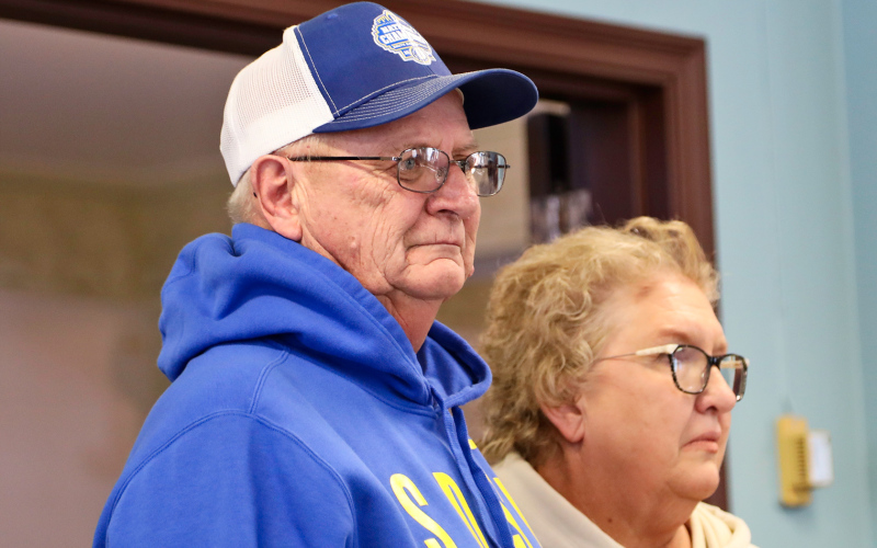Larson and his wife Connie listen as Mayor Bergeleen reads the commemoration listing  Larson’s accomplishments.
