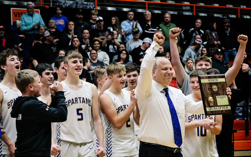 Head Boys Basketball Coach for the Spartans, Kenny Huether, holds the State Qualifier plaque up to fans after defeating Waverley-South Shore in the Soak 16.