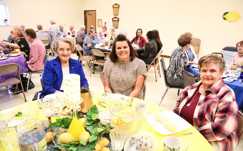 Cecile Knight with the help of Joyce Krueger decorated a lemon-themed table. She is shown with Rebecka Havlik and Linda Easton.