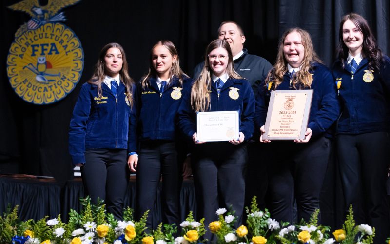 Members of the WSHS FFA Floriculture team accepting their first place South Dakota FFA Association title, left to right: Alyssa Grohs, Mariah Messmer, Mercedes Jones, Anna Arhart and Carissa Scheel. FFA Advisor Brady Duxbury stands behind the nationals-bound team. PHOTO COURTESY KATIE JONES PHOTOGRAPHY