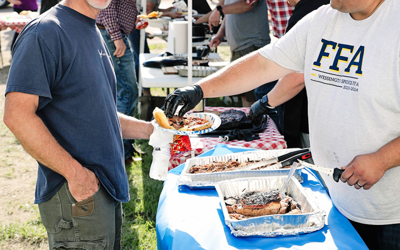 Kirk Luymes smiles as he gets his plate dished up by Brady Duxbury, one of the brisket cooks. Additional volunteer brisket cooks included Gene Gaikowski, Tyler Fagerhaug, Mike and Barbie Brunsen, Blake Willman and Chris Schimke.