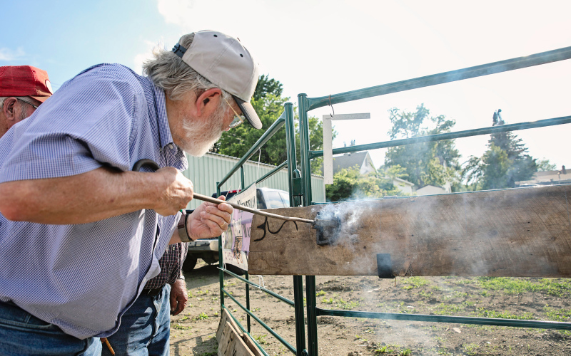 Dr. Tom Dean burns a board with his brand.