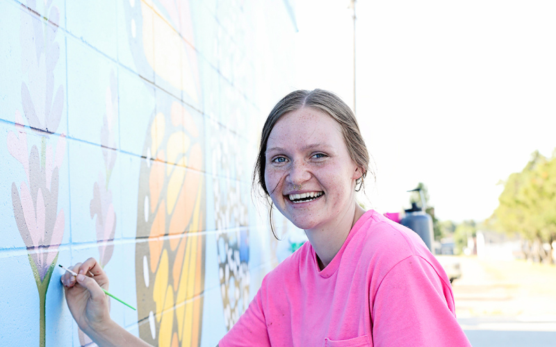 KRISTI HINE / TRUE DAKOTAN Local artist and SACOTA intern Ruthe Lindvall puts final touches on the new mural located on the east side of the Wessington Springs Pool House. Community members are invited to attend SACOTA’s official mural unveiling, set for July 4 at 12:30 p.m.