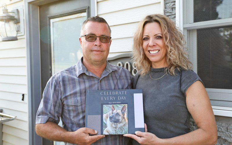 Shane and Angie Mentzer hold a photo book highlighting Ajax’s life. Many more photos of Ajax throughout his years of service as a K-9 deputy and beyond can be found at www.truedakotan.com.