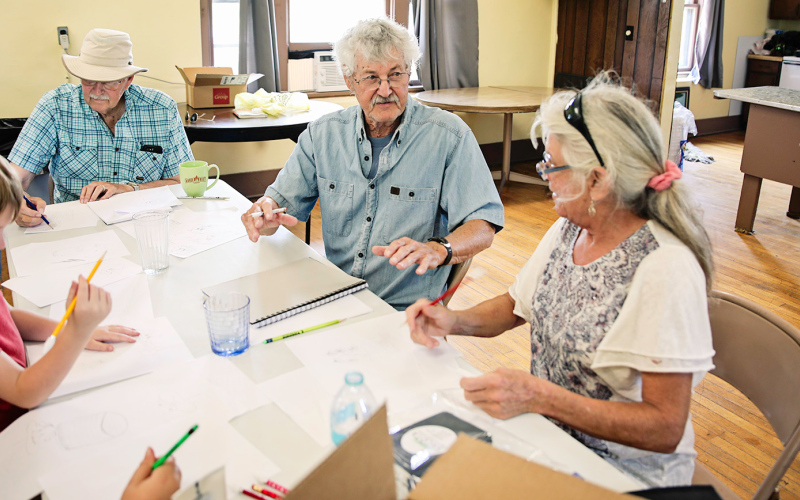 Retired art teacher Keith Swenson of Wessington Springs taught a sketch workshop at the event. He is shown with event attendee Darrell Winter (left) and SACOTA board member Cindy Eilers.