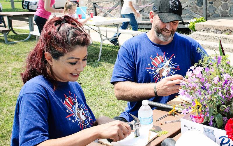 While visiting Springs from Texas, Carolyn and Jim Ferguson take part in flower hammering at Art in the Park.