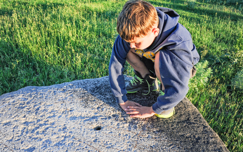 Boulders with chiseled holes are a mystery in northeastern South Dakota. Pondering the “holey rocks” of Roberts County is among the outdoor adventures South Dakota Magazine suggests with late summer in mind. PHOTO COURTESY SOUTH DAKOTA MAGAZINE