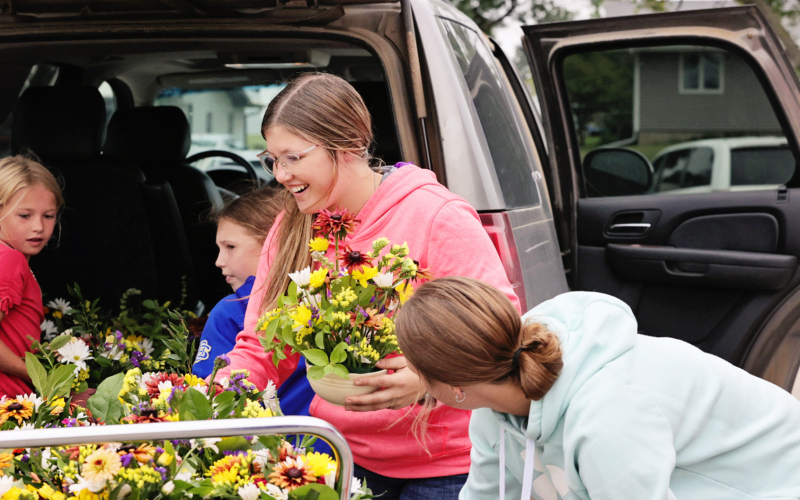 Mercedes Jones and fellow 4-Hers unload bouquets they made for nursing home residents at Weskota Manor Avera. PHOTO COURTESY KATIE JONES PHOTOGRAPHY